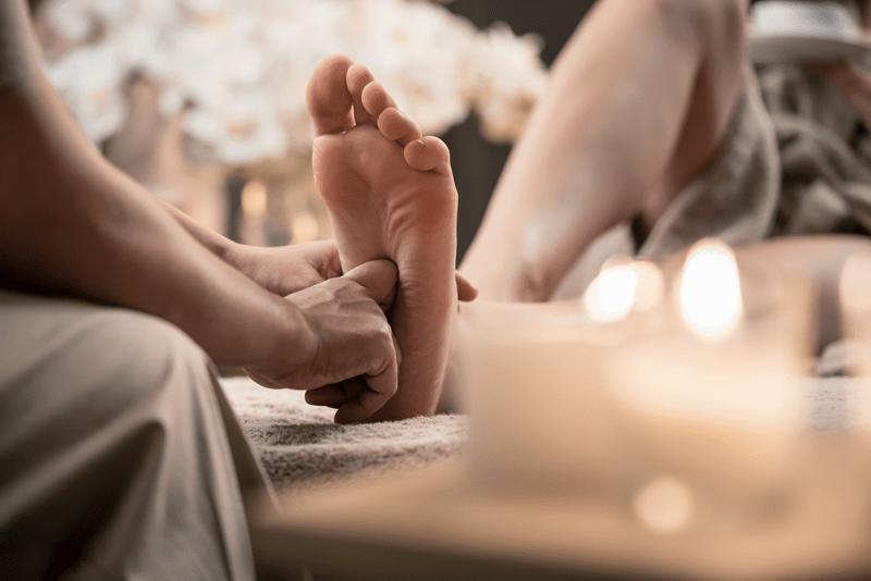 Main massant un pied pour une séance de réfléxologie