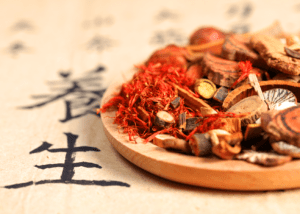 Zoom sur un parchemin accompagné de décoration de la Médecine Traditionnelle Chinoise